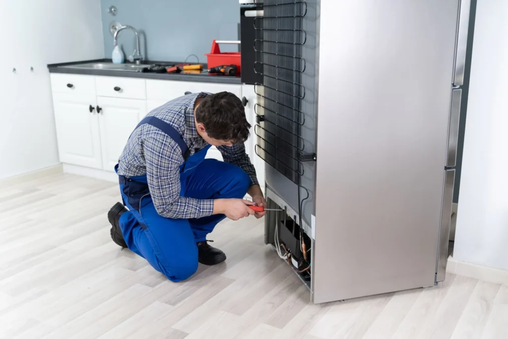 Technician providing refrigerator repair services for home appliances