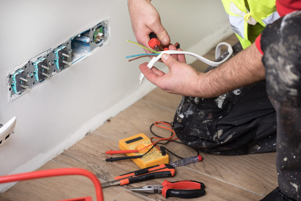 Technician providing electrical wiring services for home and office